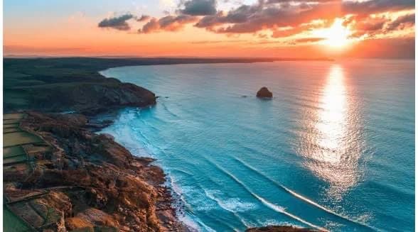 Sunset over turquoise sea and a rugged coastline
